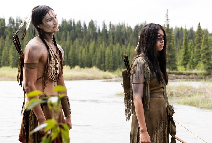 Dakota Bavers and Amber Midthunder stand near a lake in a scene from Prey.