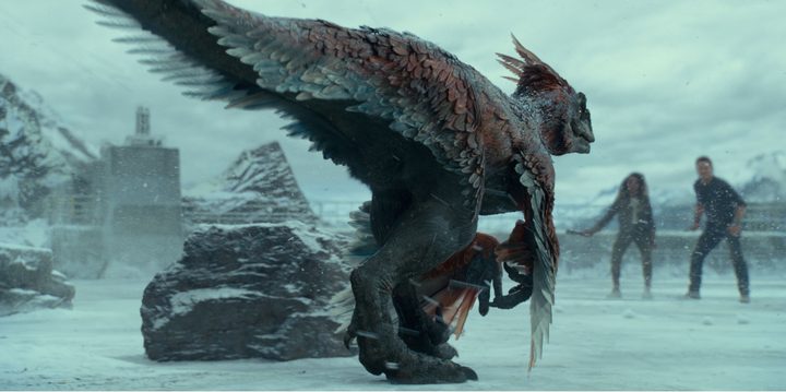 A pyroraptor stands on the ice in a scene from Jurassic World Dominion.