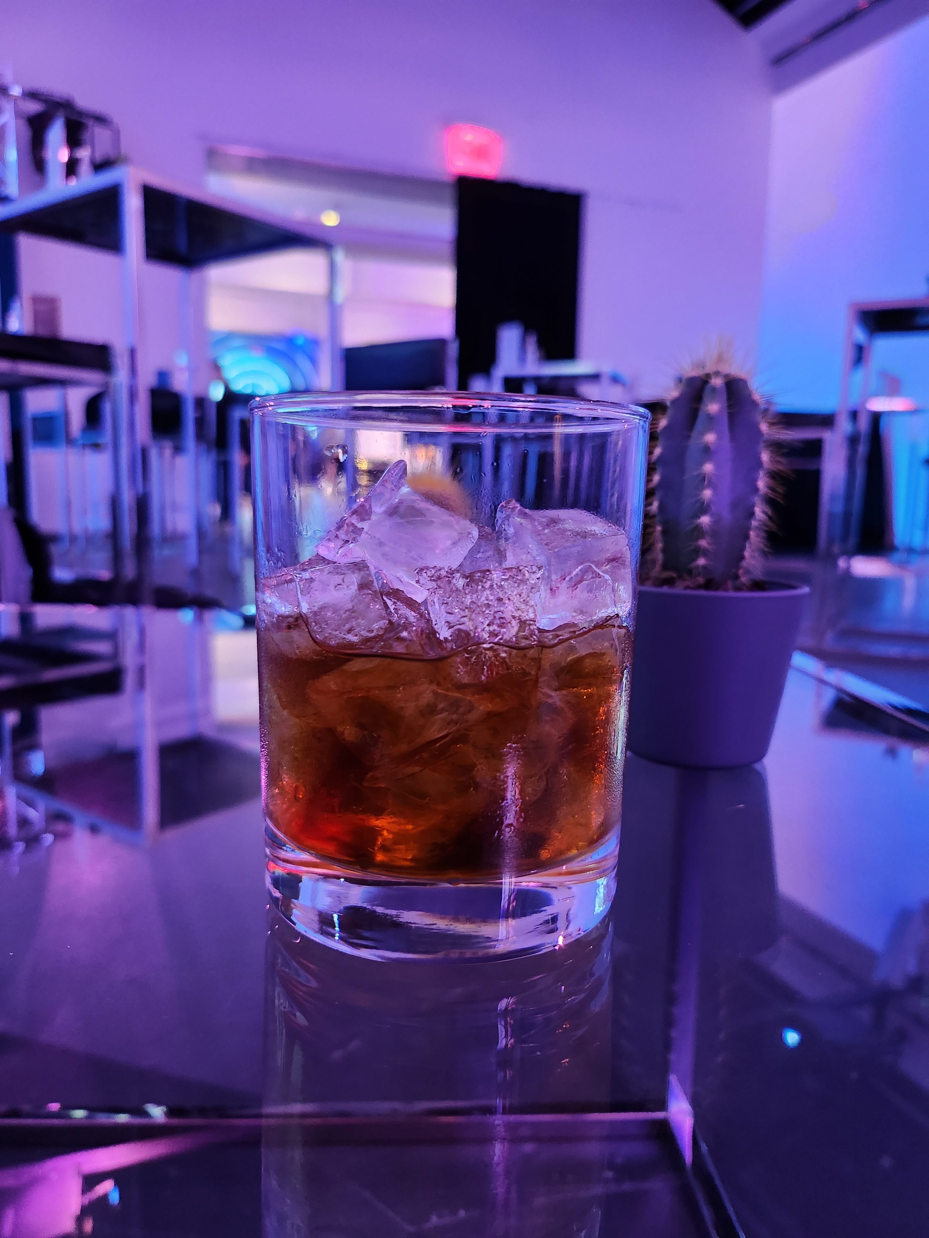 Photo of a whisky sour sitting on a glass table.