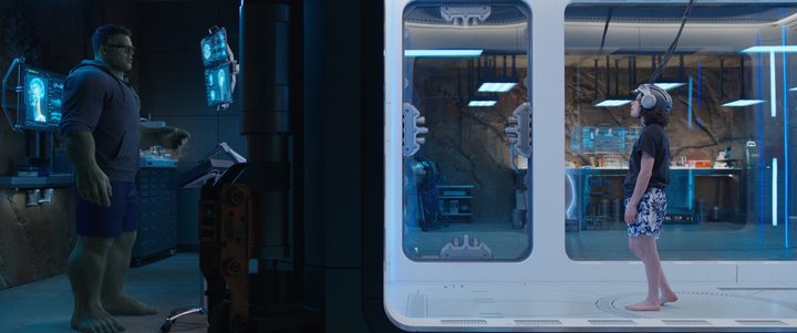 Hulk stares at Jennifer Walters, who's in a laboratory room, in a scene from She-Hulk.