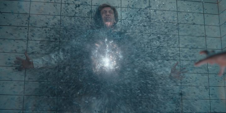 A rift forms in the middle of a character who's held against the wall i a scene from Stranger Things.