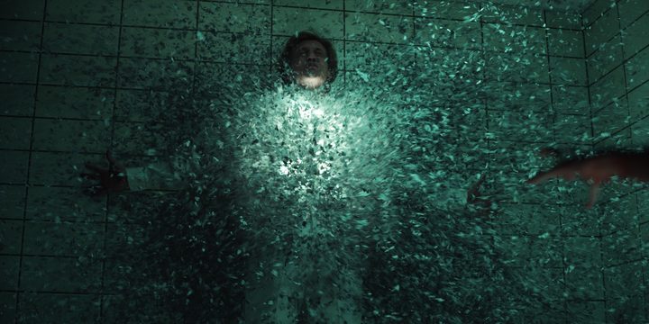 A rift forms in the middle of a character who's held against the wall i a scene from Stranger Things.