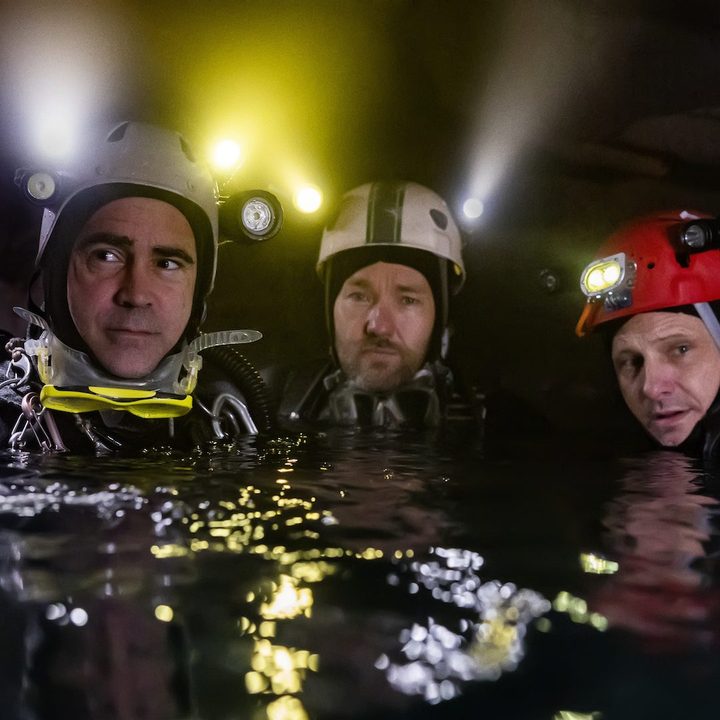 Colin Farrell, Joel Edgerton, and Viggo Mortenson stand in the water in a scene from Thirteen Lives.