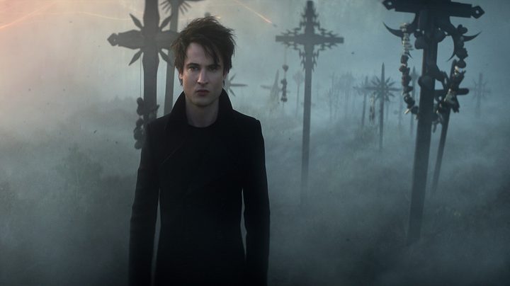Tom Sturridge as Morpheus stands in front of a misty backdrop in a scene from The Sandman.