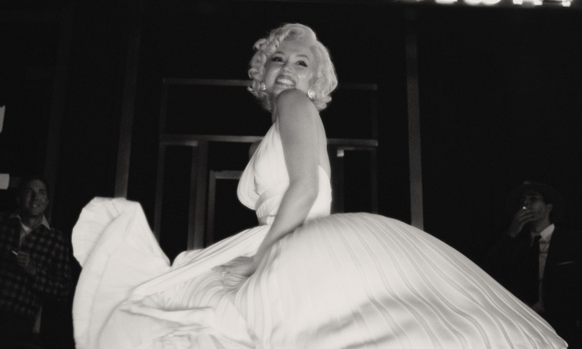 Ana de Armas smiles while wearing a billowing white dress in Blonde.