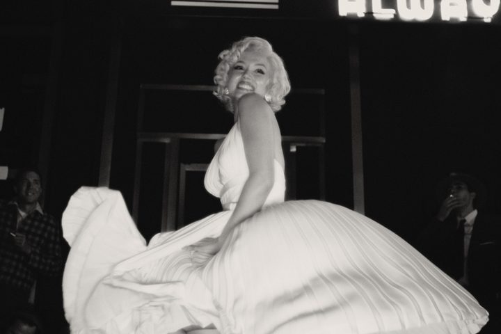 Ana de Armas smiles while wearing a billowing white dress in Blonde.