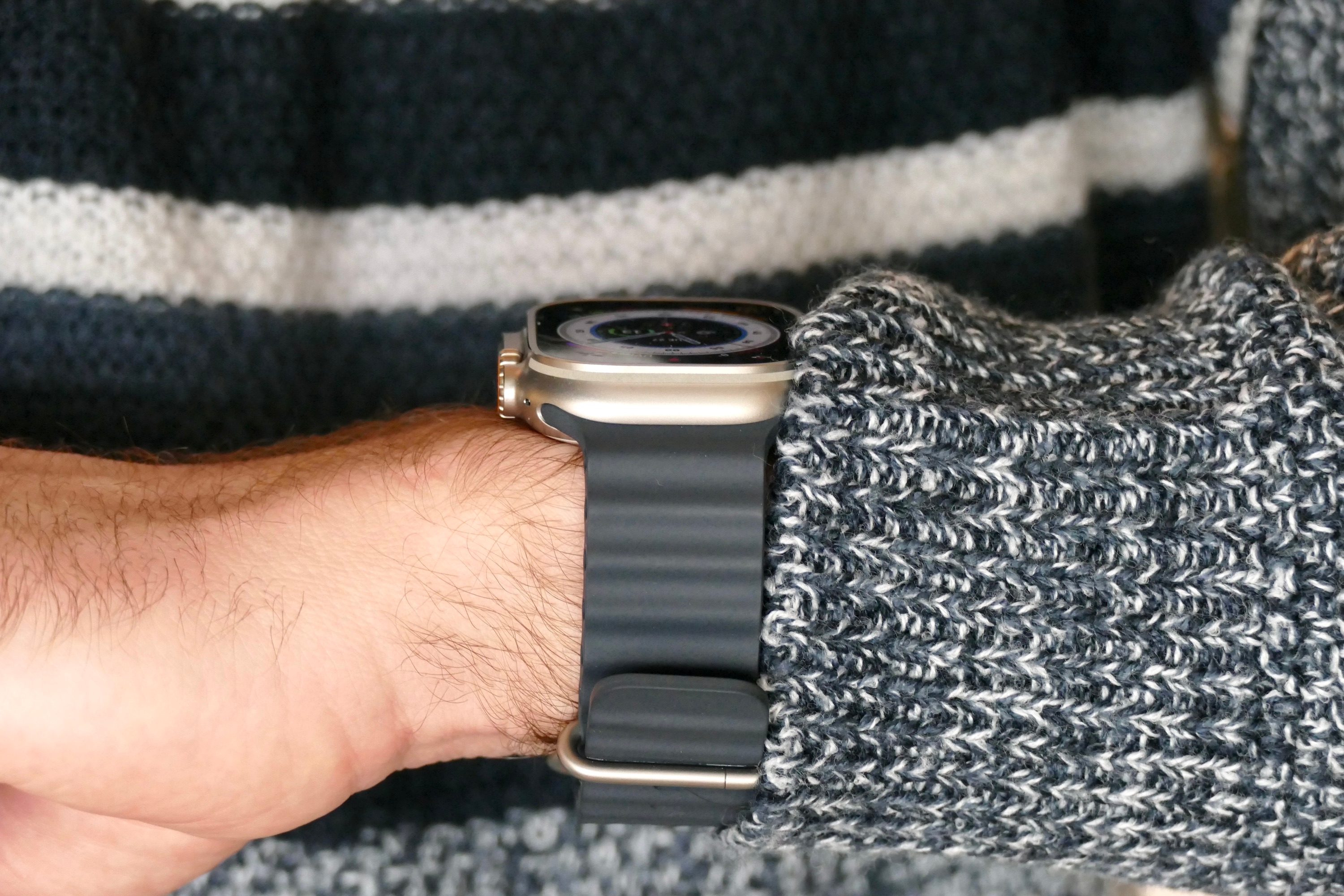 The back side of the Apple Watch Ultra, worn on a man's wrist.
