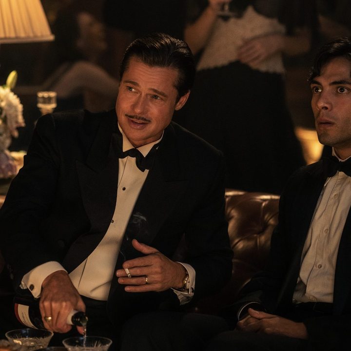 Brad Pitt and Diego Calva sitting down and drinking in a scene from Babylon.