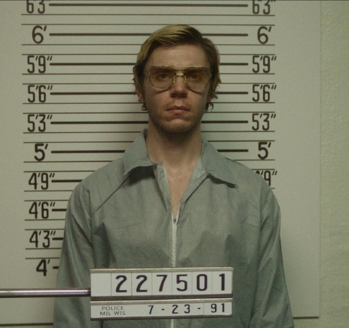 Evan Peters in front of a police lineup in a scene from Dahmer.