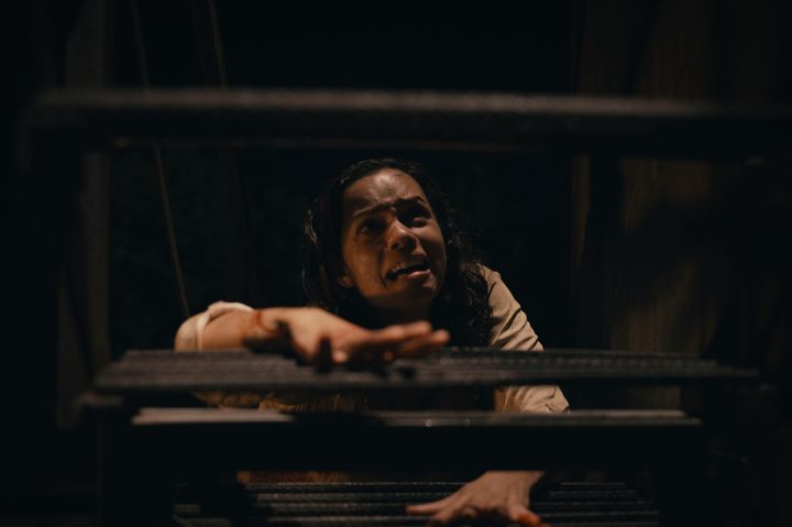 Georgina Campbell crawls up a metal staircase in Barbarian.