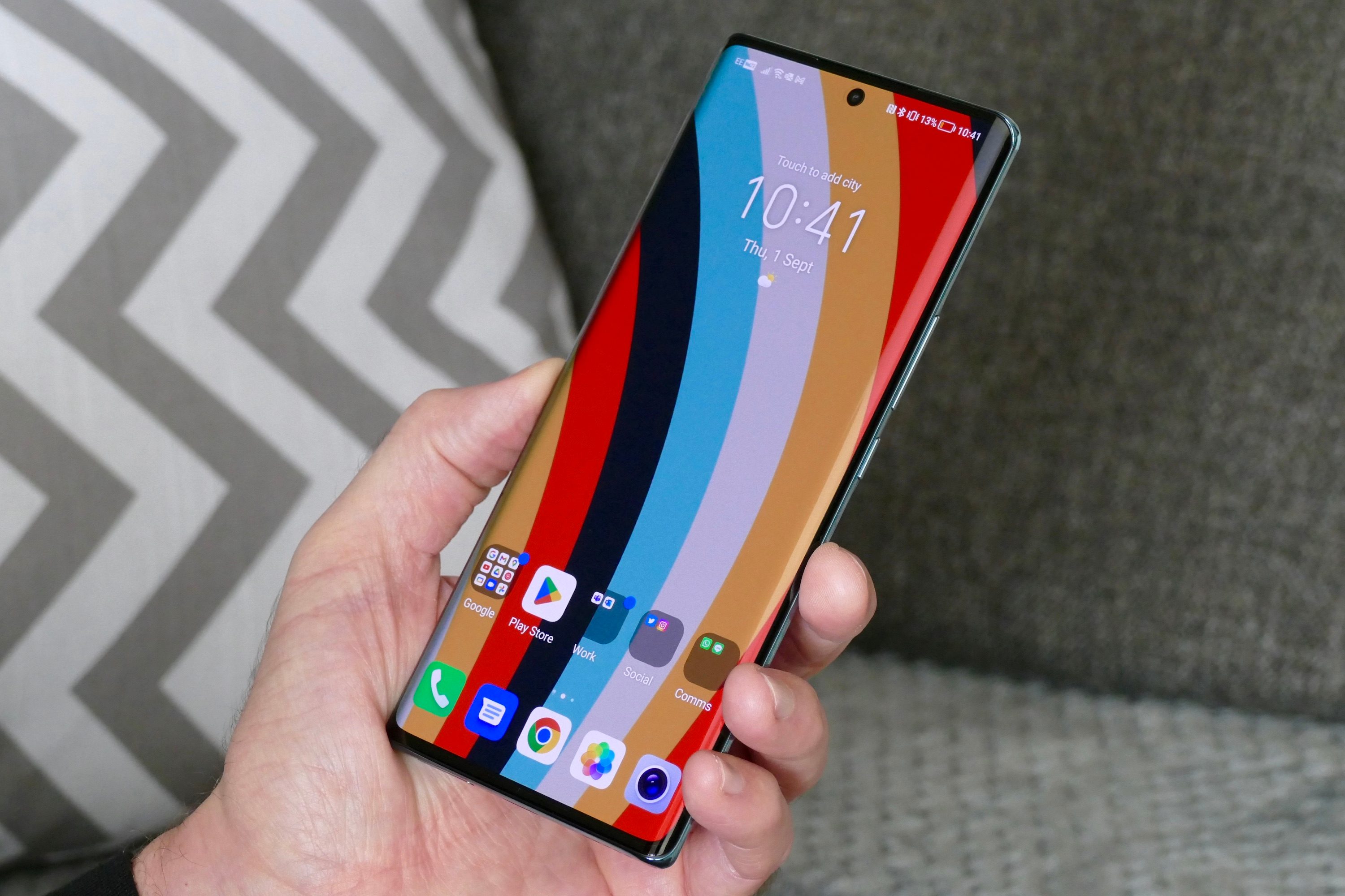 The Honor 70 held in a mans hand, showing the screen.