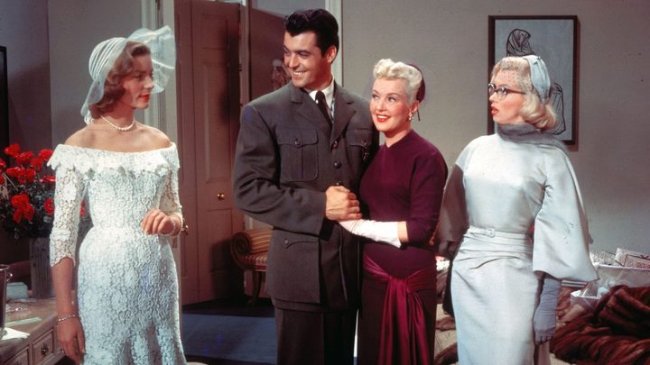 Two women looking at a couple with confused expressions in the film How To Marry A Millionaire.