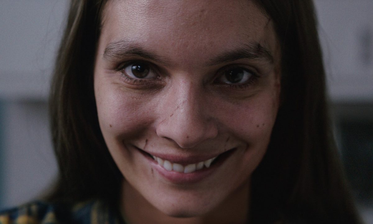 Caitlin Stasey smiles, unnervingly.