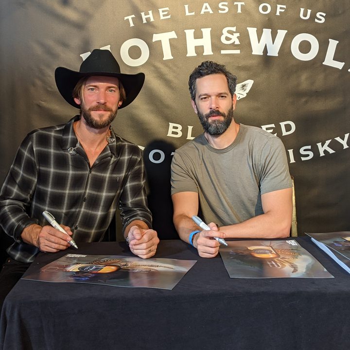 Troy Baker and Neil Druckmann signing posters at the Moth & Wolf tasting event.