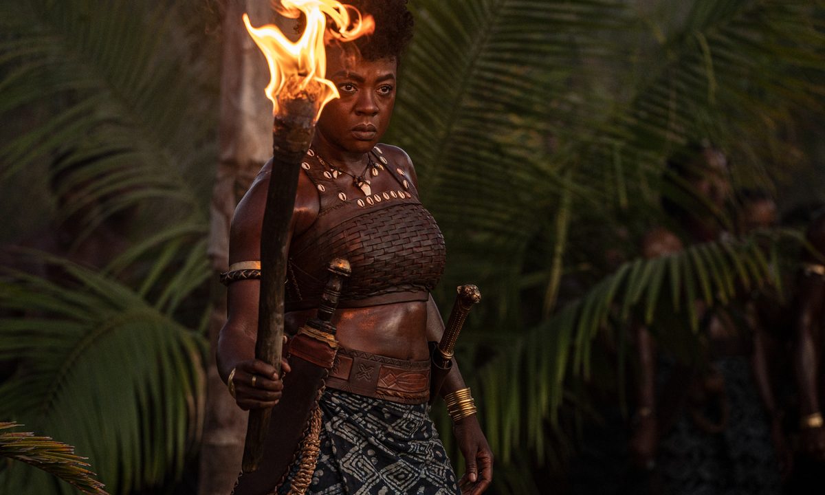 Viola Davis holds a torch in The Woman King.
