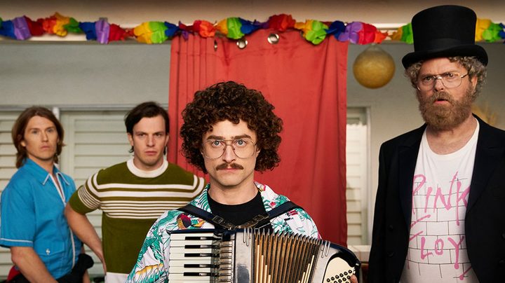 Daniel Radcliffe and Rainn Wilson stare at the camera.