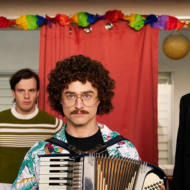 Daniel Radcliffe and Rainn Wilson stare at the camera.