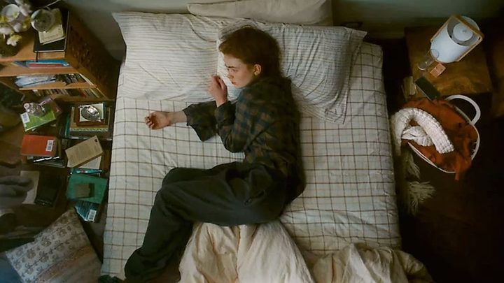 Sadie Sink lays on the bed in All Too Well.