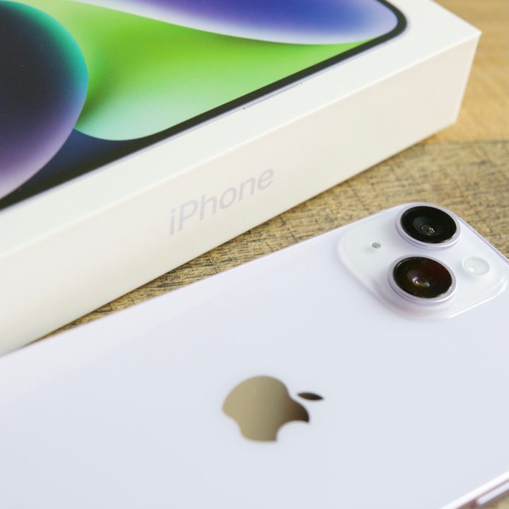 An iPhone 14 lying next to its retail box.