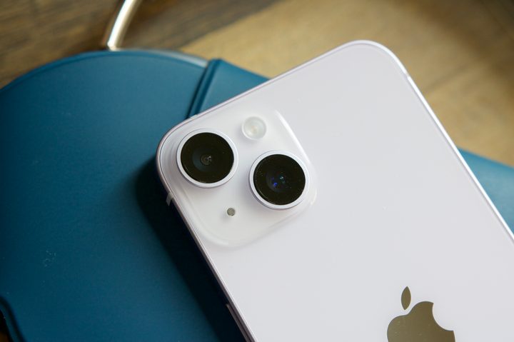 iPhone 14 laying on top of a pair of AirPods Max.