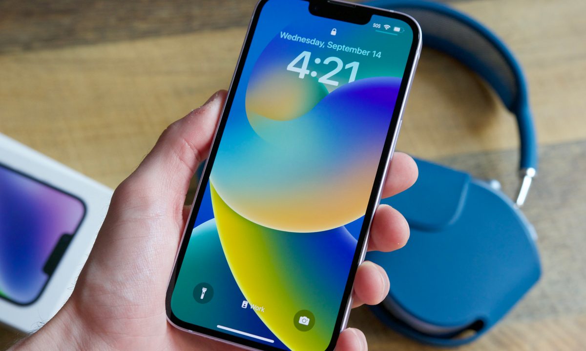 Someone holding an iPhone 14, showing the Lock Screen.