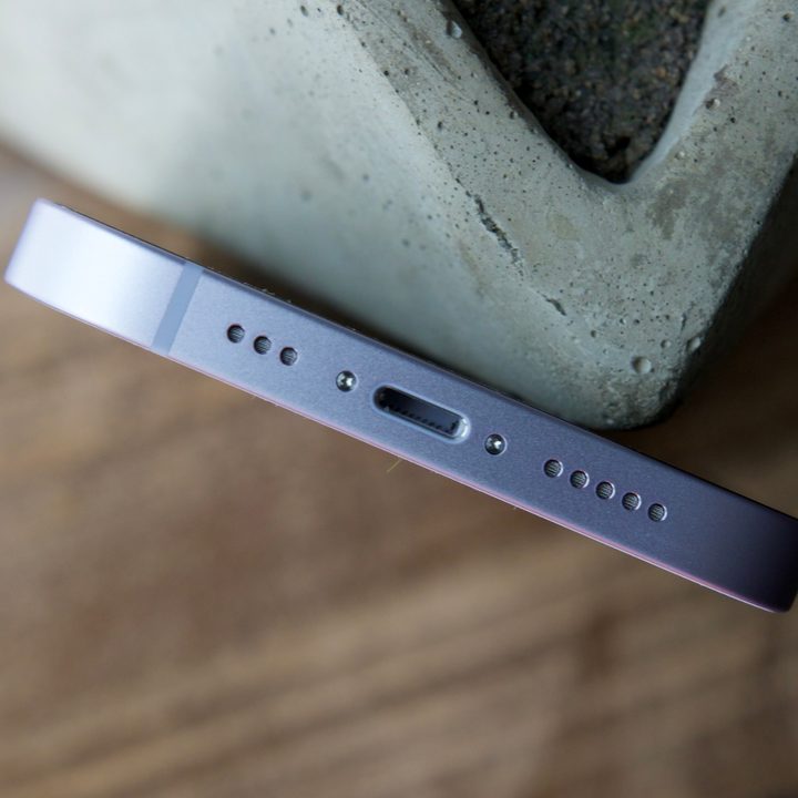 The bottom of an iPhone 14, showing its speaker grille and Lightning port.