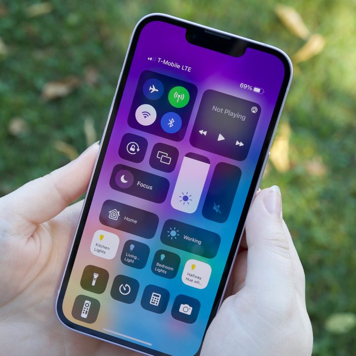 Someone holding an iPhone 14. The display is turned on and showing the Control Center.