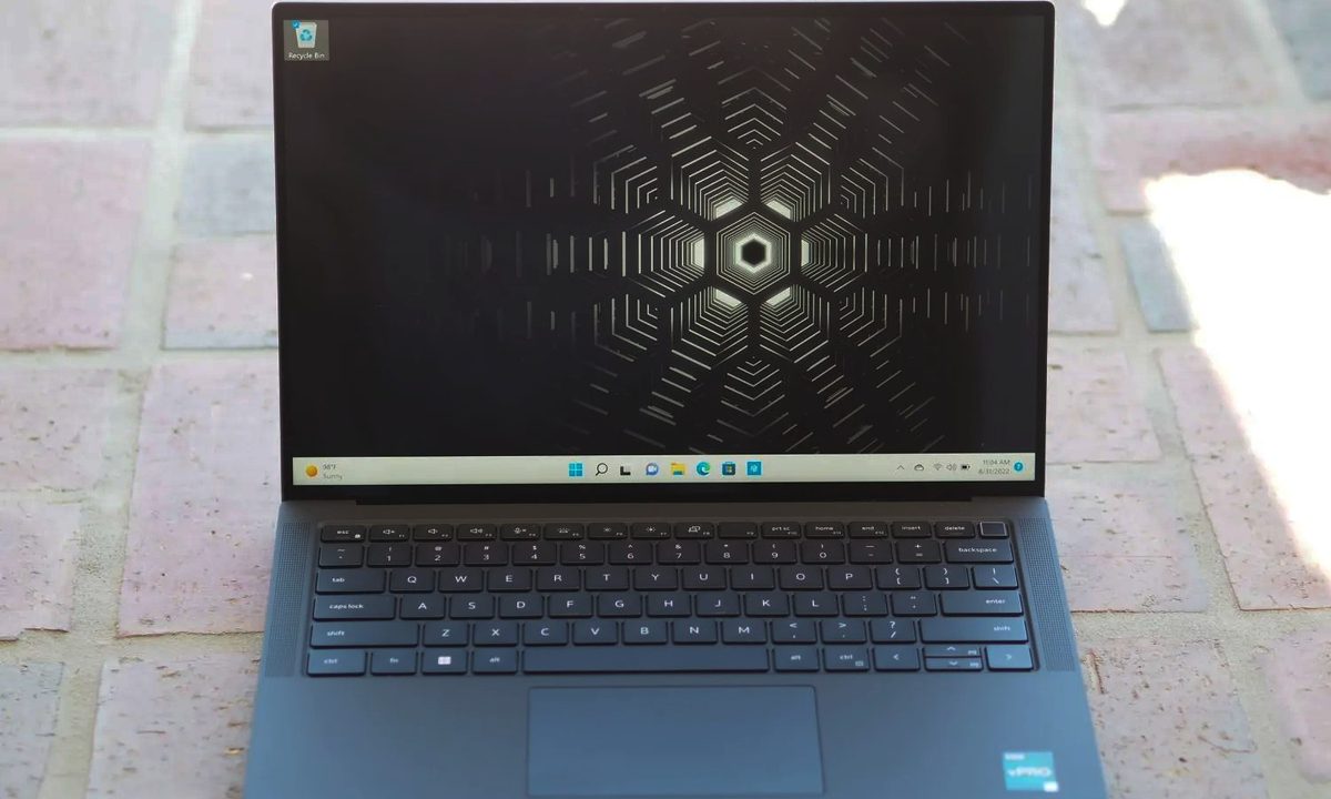 A Dell Precision laptop on a brick floor.