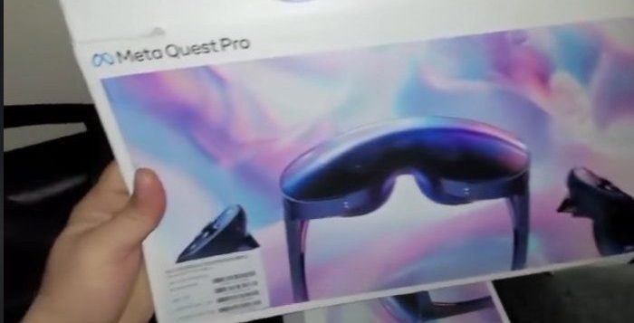 A hand holds a white Meta Quest Pro box with an iimage of the headset on the front