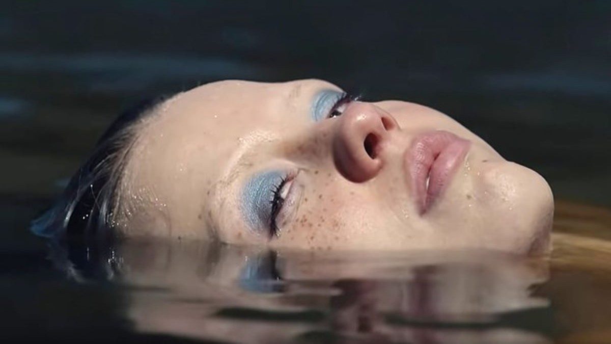 Mia Goth floats in a lake in X.