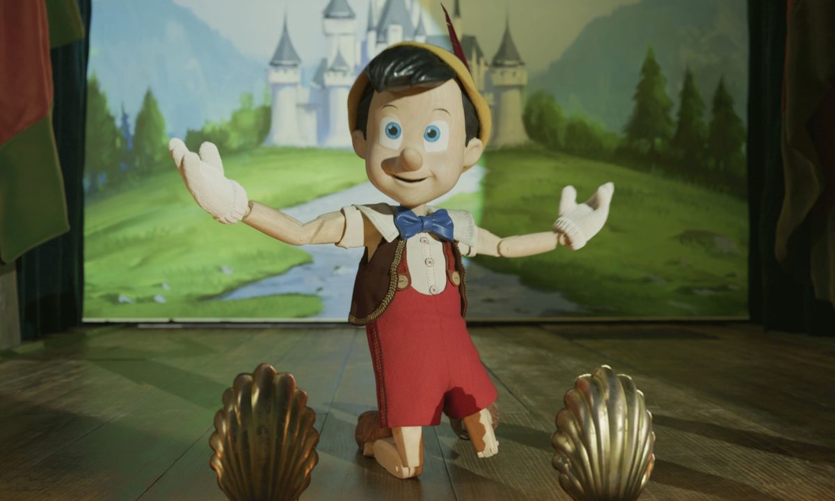 Pinocchio kneels on stage in a scene from the 2022 live-action film.