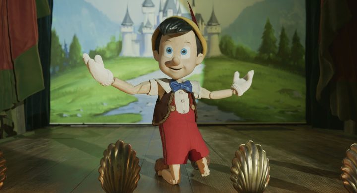 Pinocchio kneels on stage in a scene from the 2022 live-action film.
