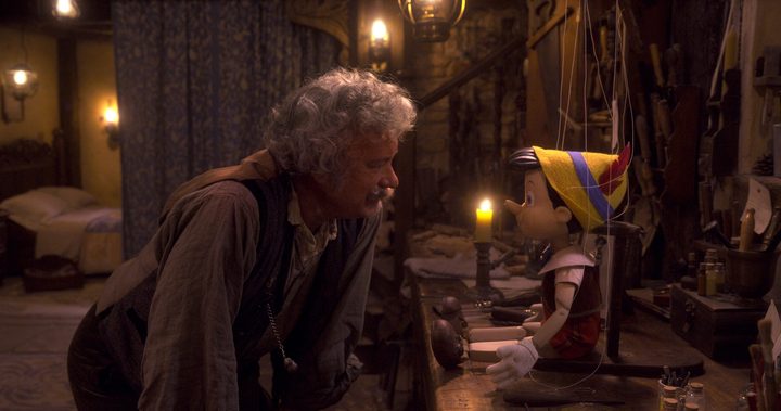 Tom Hanks as Geppetto leans in to talk to Pinocchio in a scene from the 2022 film.