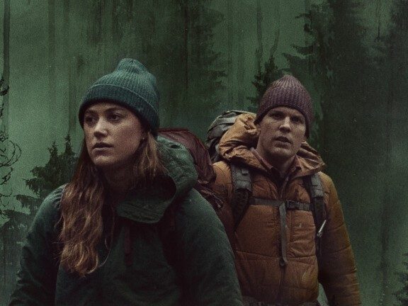 Maika Monroe and Jake Lacy wander through a forst in a promotional image from Significant Other.