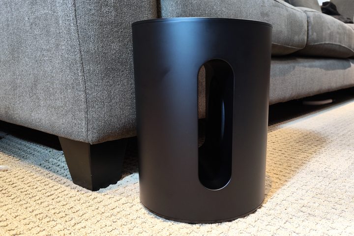 Sonos Sub Mini in front of a sofa.