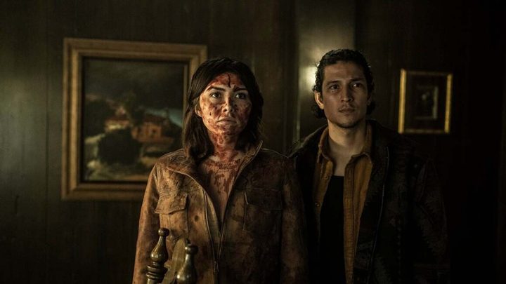 A young couple covered in blood standing in a home in a scene from Tales of the Walking Dead.