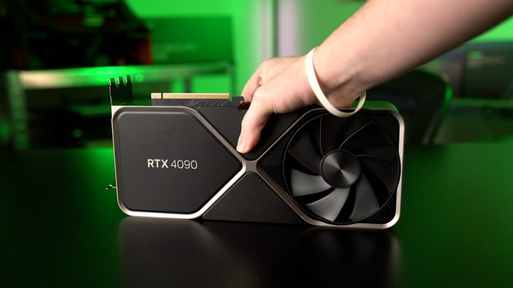 A hand holding the RTX 4090 GPU.