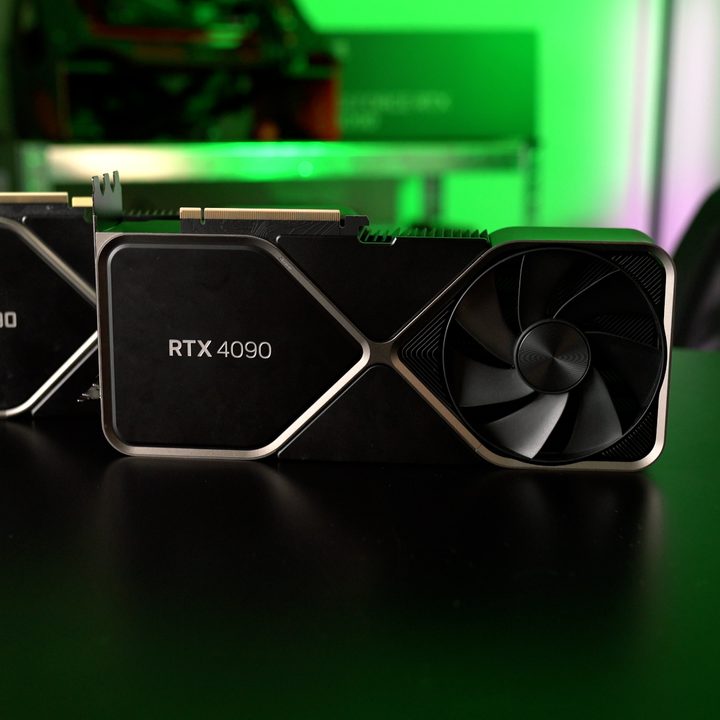 The RTX 4090 and RTX 3090 sitting on a table side-by-side.