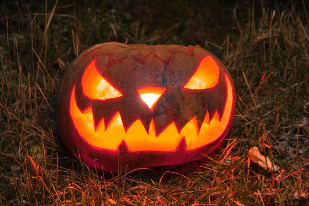 Jack O lantion in the grass at night.