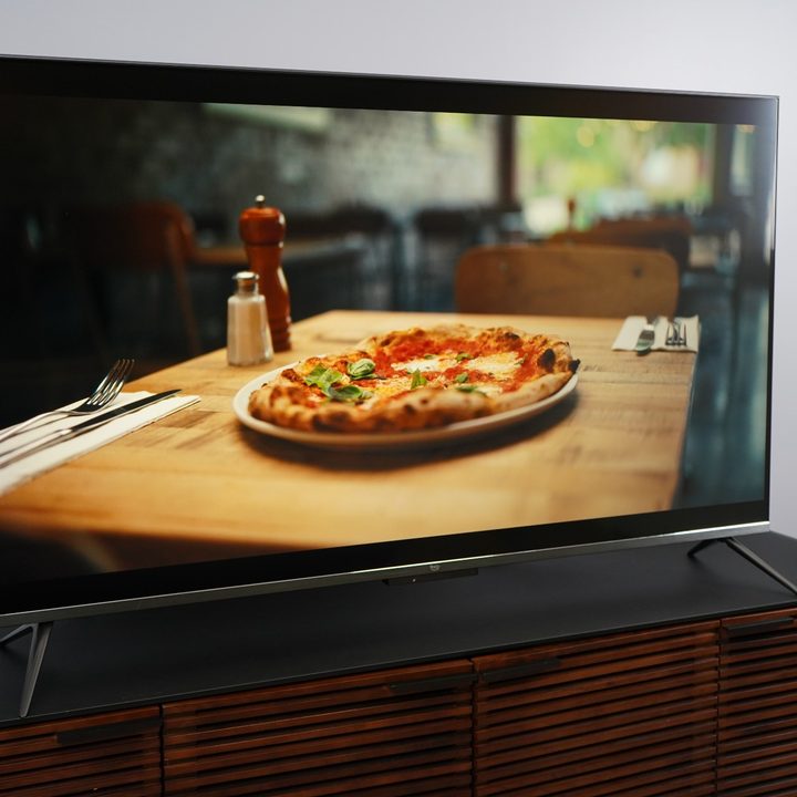 Amazon Fire TV Omni QLED with an image of a delicious looking pizza on the screen, rich with color.