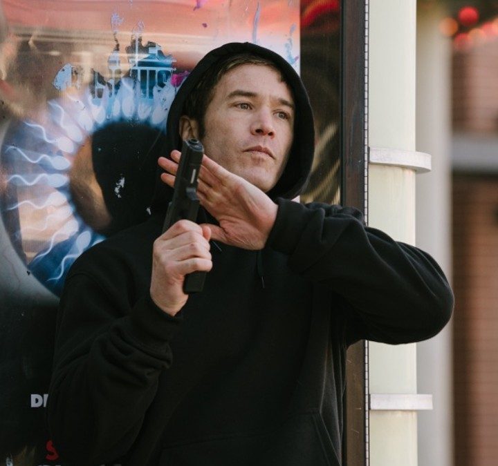 Tom Pelphrey holds a gun in a scene from American Murderer.
