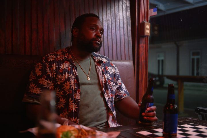 Brian Tyree Henry sits in a bar booth in Causeway.