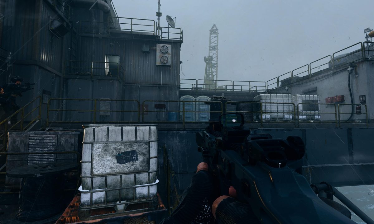 two blue porta-potties on an oil rig in the rain