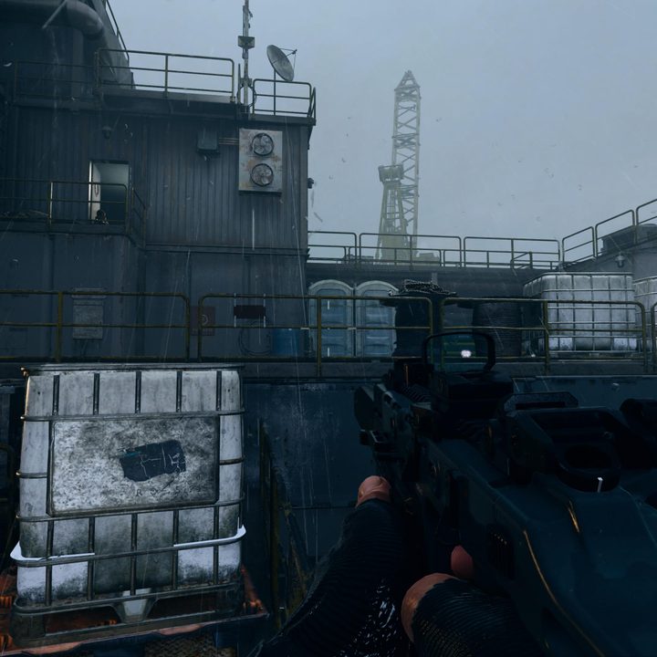 two blue porta-potties on an oil rig in the rain