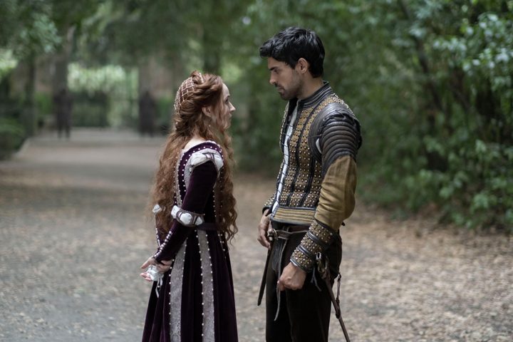 Kaitlyn Dever stands on a forest road with Sean Teale in Hulu's Rosaline.