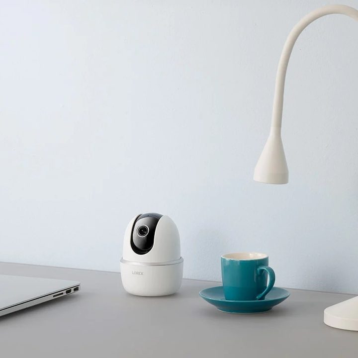 Lorex 2K Pan-Tilt Indoor Wi-Fi security camera on desk.