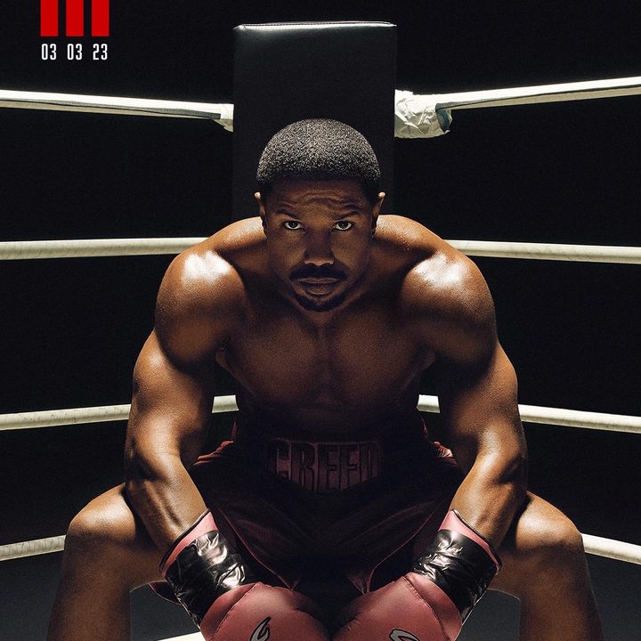 Michael B. Jordan sits on a stool in a boxing ring in a scene from Creed III.
