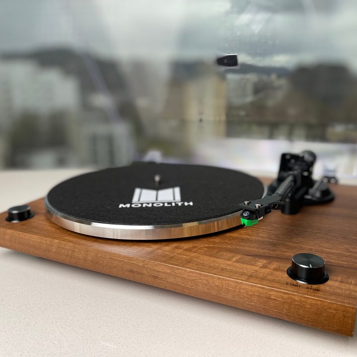 The monoprice monolith tunrtable with clear dust cover raised.