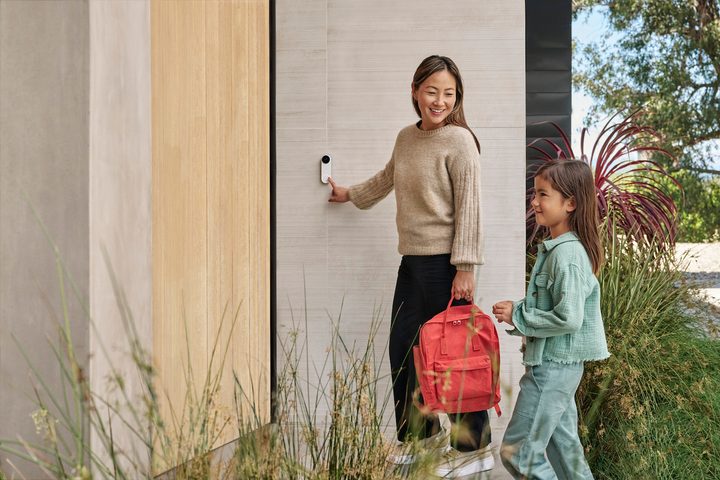 Someone presses the Nest Video Doorbell in front of their home.