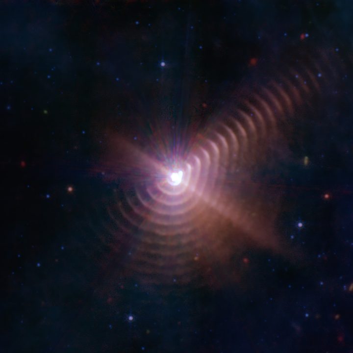 Shells of cosmic dust created by the interaction of binary stars appear like tree rings around Wolf-Rayet 140.